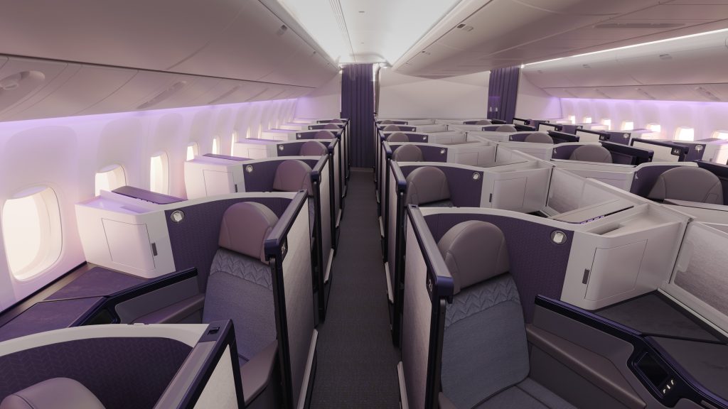 Business class cabin with private lie-flat seats in purple, arranged in individual pods along two aisles.