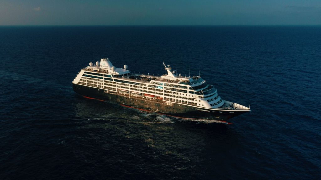 Azamara cruise ship with multiple decks sailing in the deep blue ocean under a clear sky